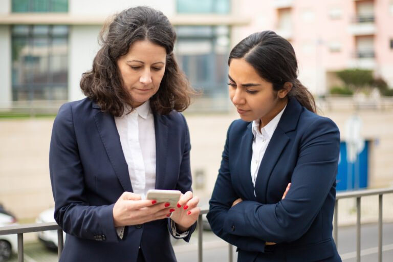 Serious businesswomen using smartphone
